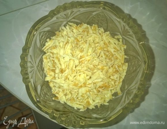 После этого каждый из испеченных блинов также нарезаем тонкой соломкой и добавляем в общую салатницу к ранее порезанному куриному окорочку.