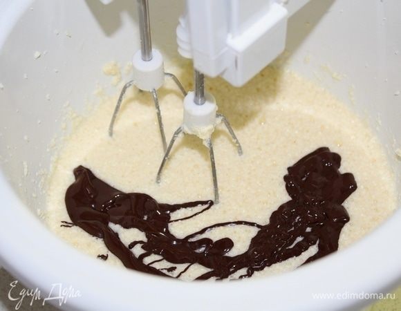 Сливочное масло взбить с сахаром, затем по одному вбить яйца. Затем добавить остывший шоколад.