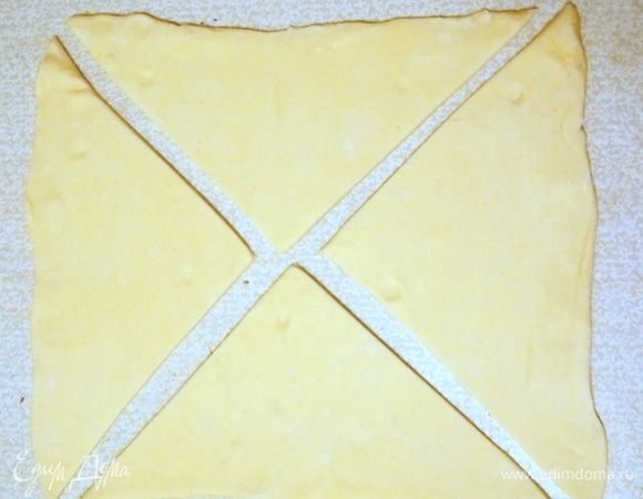 Слоеное тесто разморозить и раскатать не очень сильно. Разрезать по диагонали на четыре треугольника.