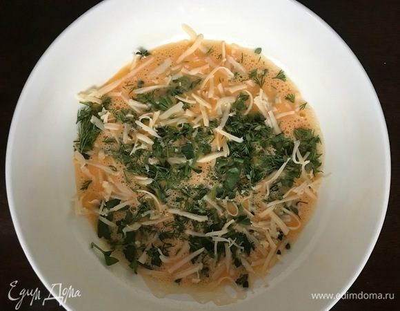 В яичную массу добавляем порубленную зелень и большую часть сыра.