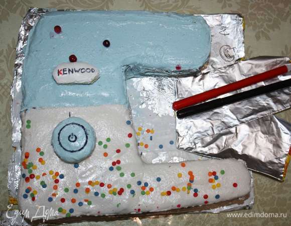 С помощью сметаны крепим надпись, а кнопку — с помощью спички. Пищевыми фломастерами дорабатываем детали.  