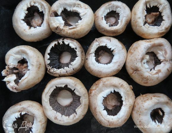 Из шампиньонов извлечь ножки, сами шампиньоны выложить в форму для запекания и посолить. 