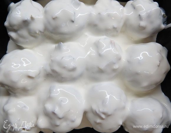 Для сметанного соуса сметану немного развести водой до текучей консистенции, полить сверху шампиньоны. Выпекать в разогретой до 180°С духовке 35-40 минут.