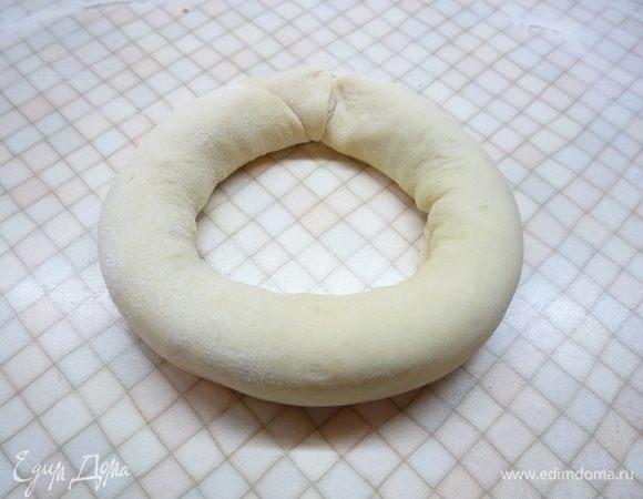 Скатываем тесто в рулет по длинной стороне, соединяем концы и тщательно защипываем швы.