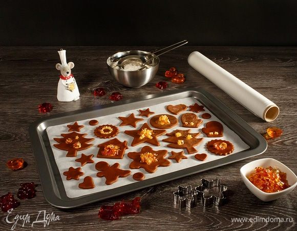 Разогреваем духовку до 180°С.  
Раскатываем тесто толщиной примерно 3 мм. Можно использовать силиконовый коврик или бумагу для выпечки. Делаем фигурки и «окошки» всевозможных форм. Леденцы разбиваем в плотном пакетике кухонным молоточком и засыпаем леденцовую крошку в «окошки» нашего печенья. Чтобы получилось аккуратно, помогаем пинцетом. Я предпочитаю использовать леденцы своего изготовления, но можно взять и обычные разноцветные конфетки.