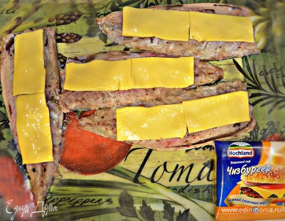 Пластины сыра Hochland разрезать пополам и выложить вдоль рыбного филе.