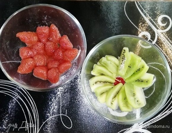 В креманки выложите любые фрукты. У меня киви и консервированная клубника.