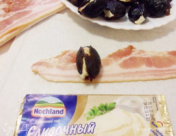 Затем завернуть фаршированный чернослив  в бекон. 