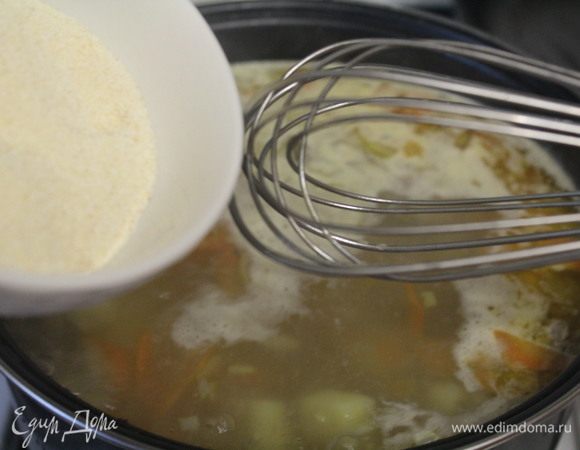 Дать закипеть. Помешивая венчиком, ввести манную крупу.