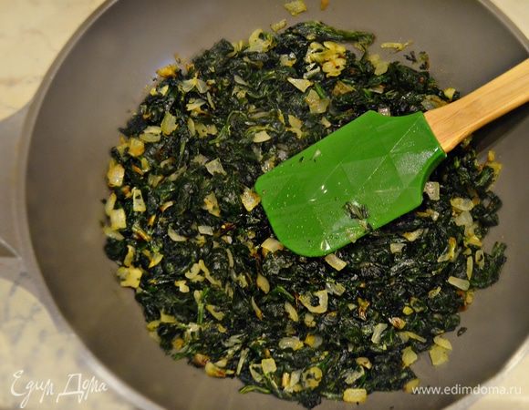 На оливковом масле обжарьте два раздавленных зубчика чеснока, затем выньте их из масла, они нам больше не понадобятся. Обжарьте в этом же масле лук до золотистого цвета, добавьте шпинат и потушите в течение 3 минут, помешивая. Приправьте солью и перцем.