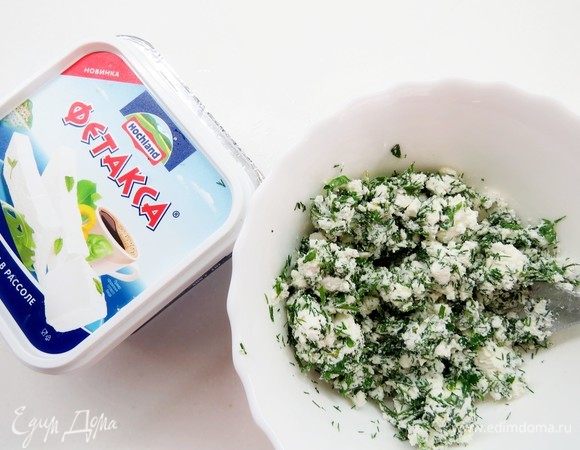 Фетаксу Hochland размять вилкой, добавить измельченный через чеснокодавку чеснок и нарезанную зелень, перемешать.