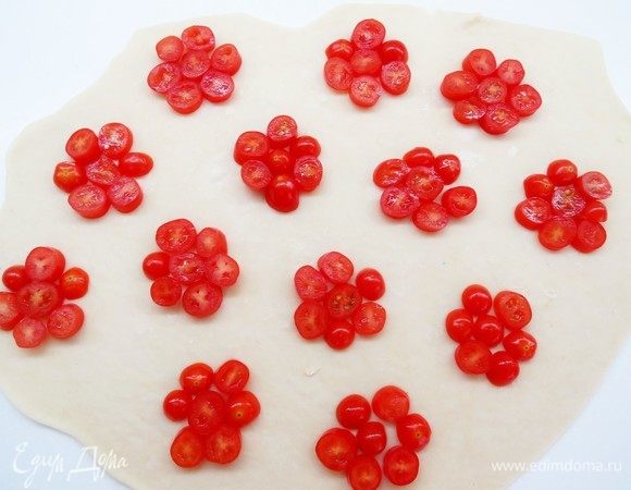 Раскатать половину теста в большой тонкий пласт.
Разложить на тесто кружочки помидоров не ближе, чем 3 см друг от друга.