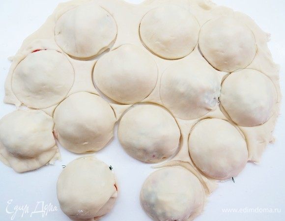 Стаканом подходящего диаметра или круглой вырубкой вырезать пирожки по контурам каждого кружочка помидора, так поступаем со всеми пирожками.