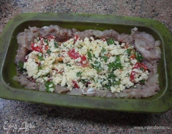 В форму (силиконовую можно не смазывать) выложить большую часть фарша, формируя бортики. Заполнить начинкой.