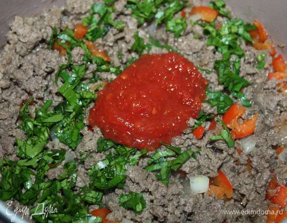 Далее добавляем мелко нарубленную петрушку и томатное пюре, перемешиваем и тушим почти до готовности.