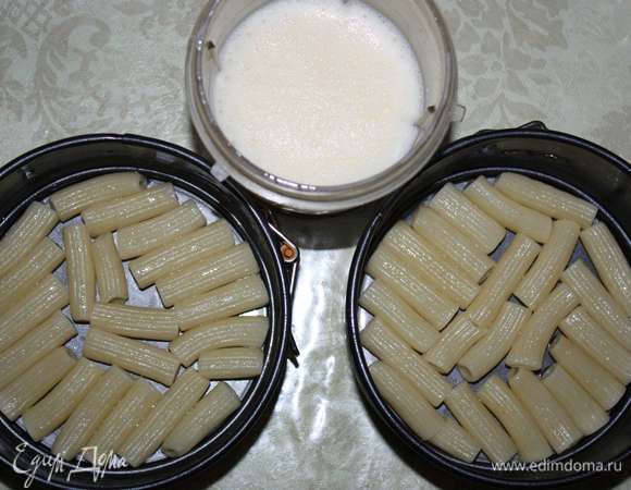 На дно формы выкладываем половину макарон. Яйцо взбиваем.