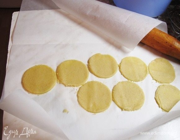 Раскатать тесто между двумя листами для выпечки до толщины 2–3 мм. Вырезать кружочки, равные диаметру пирожных, около 5 см.
Положить в морозилку вместе с листами.