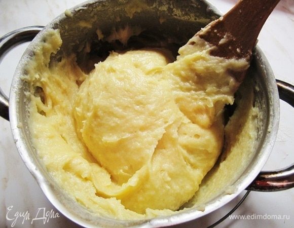 Горячее тесто снимаем с огня. Включаем духовку на 200°С.
В горячее тесто начинаем лопаткой подмешивать яйца, постоянно помешивая и взбивая тесто.