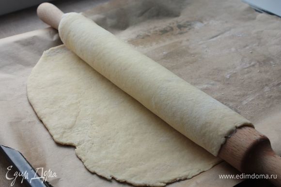 Охлажденное тесто разделите на 2 части — большую и меньшую. Большую часть раскатайте и выложите на смазанный сливочный маслом противень или бумагу для выпечки, это будет основание пирога.