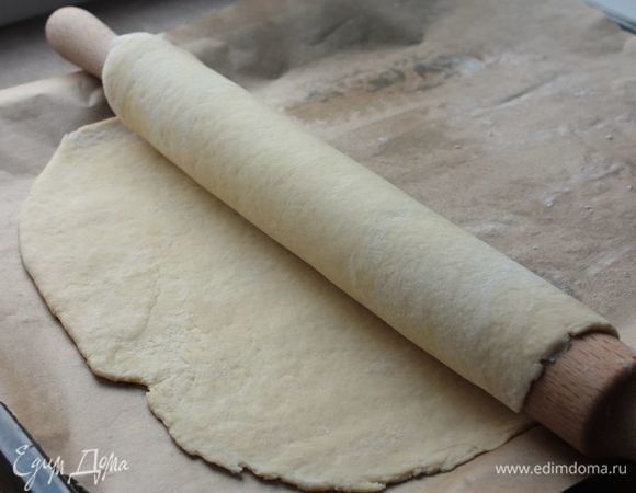Охлажденное тесто разделите на 2 части — большую и меньшую. Большую часть раскатайте и выложите на смазанный сливочный маслом противень или бумагу для выпечки, это будет основание пирога.