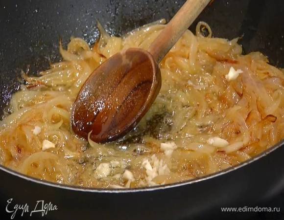 Чеснок почистить, раздавить плоской стороной ножа, мелко порубить и добавить в сковороду с луком, все поперчить, перемешать и еще немного прогреть.