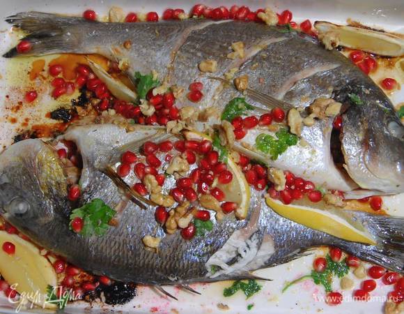 Готовую рыбу посыпать оставшейся кинзой, поломанными руками грецкими орехами и зернами граната, сбрызнуть оливковым маслом и соком лимона.