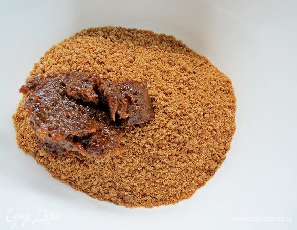 Делаем основу. Измельчить имбирное печенье вместе с черносливом в блендере в мелкую крошку и смешать со слегка растопленным сливочным маслом. 