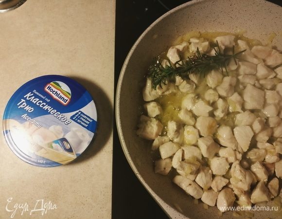 Добавить филе, нарезанное кубиками, веточку розмарина. Тушить на среднем огне 5–6 минут.