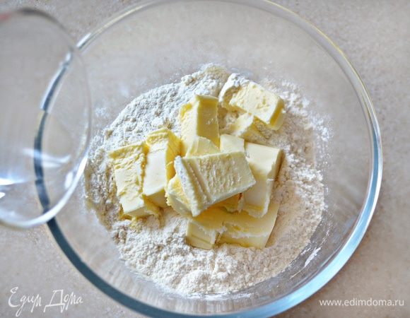 К муке добавьте рубленое масло, щепотку соли и 2 ст. л. холодной воды, замесите тесто.