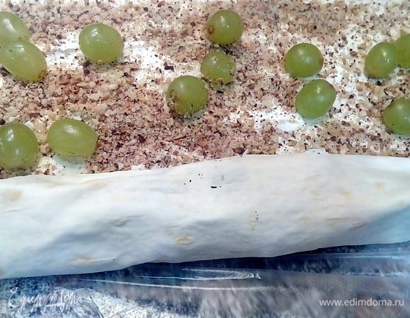 Далее на первой половине лаваша с сахаром посыпать молотыми лесными орехами, выложить произвольно ягоды винограда.
На второй половине лаваша также сверху сыра разровнять творог и выложить кусочки любимой красной рыбы. Сворачиваем лаваш в рулеты и нарезаем на роллы.