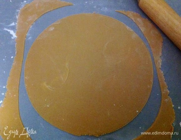 Теперь этот кусочек раскатываем скалкой тонко на столе, посыпанном мукой, чтобы корж при раскатке не прилипал, и вырезаем диаметр, который вам надо, я делала 24 см, вырезала по кругу большой тарелки.