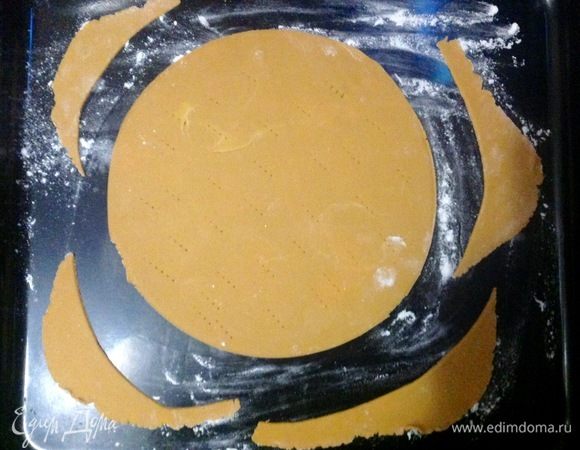 Духовку уже нагрели предварительно на 180°С, теперь посыпаем противень мукой, выкладываем на него корж и обрезки от коржа, корж протыкает вилкой по всей поверхности для того, чтобы он не вздувался при выпечке.