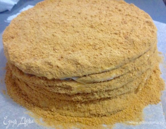 Посыпаем корж сначала по боками крошкой, затем — сверху.