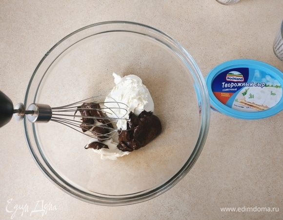 На минимальной скорости начать взбивать творожный сыр Hochland с растопленным шоколадом. 