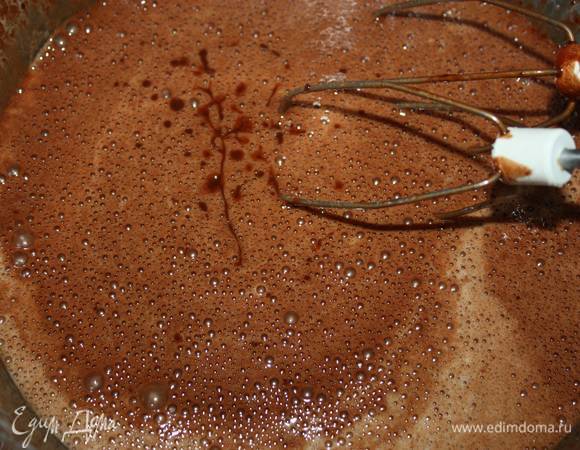 Затем нужно снизить скорость и тонкой струйкой влить в яичную смесь остывшую шоколадную массу. 