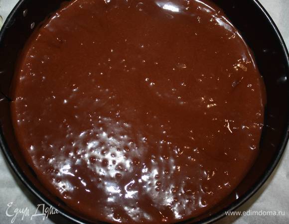 Разъемную форму необходимо выстелить пергаментной бумагой. Выложить половину темной массы.