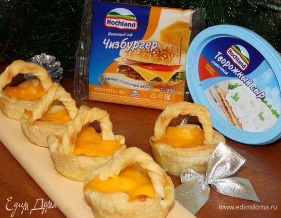 Выпекать корзиночки в течение 30–35 минут. Духовку предварительно разогреть до 200°С. Вынув из духовки каждую «корзиночку», накрыть кусочком плавленого сыра Hochland и вставить ручки. 