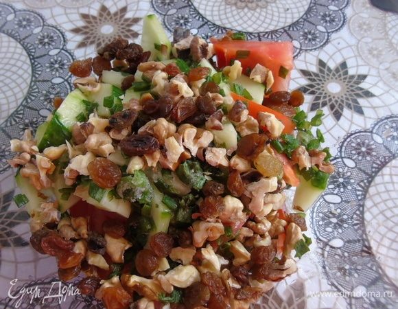 В салатнике смешайте нарезанный зеленый лук, огурцы, помидоры, орехи, изюм.