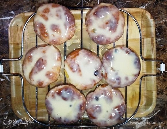 Поставьте кексы на решетку и полейте глазурью. Она немного впитается в кексы, поэтому соберите глазурь под решеткой и чайной ложкой выложите ее на кексы. 