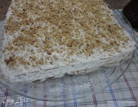 Коржи смазать кремом, так же бока и верх смазать кремом и посыпать орехами. Выдержать в прохладном месте не менее 8 часов.