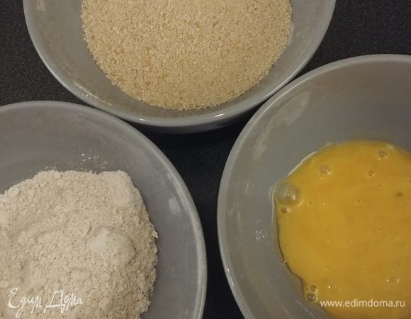 Подготавливаем 3 миски: с мукой, с сухарями и с яйцами. Обваливаем кусочки курицы сначала в муке, затем в яйце и очень хорошо в панировочных сухарях.