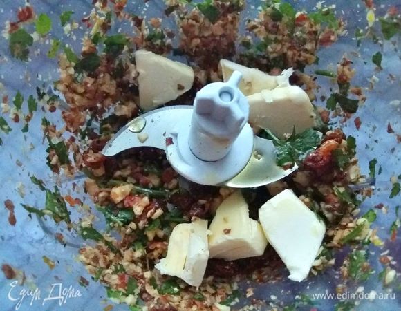 Добавить сливочное масло, нарезанное кусочками, плюс к нему оливковое масло и все измельчить в пасту с небольшими кусочками.