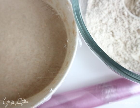 Разделить муку на две равные части. В одну из них добавить воду с маслом и сахаром, хорошо перемешать. Затянуть миску пленкой и оставить на 30 минут при комнатной температуре. 