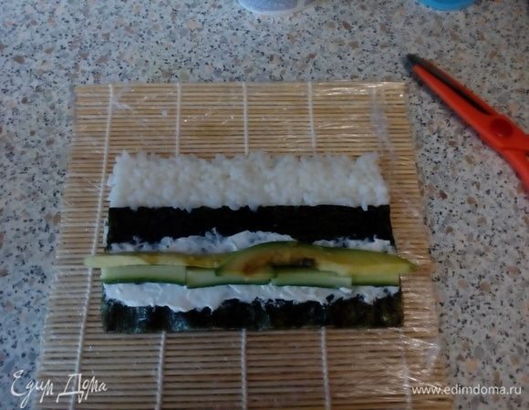 Смазать нори творожным сыром, выложить бруски авокадо и огурца.