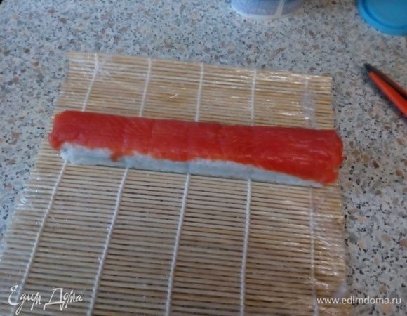 Выложить рыбу и прижать ее к роллу.