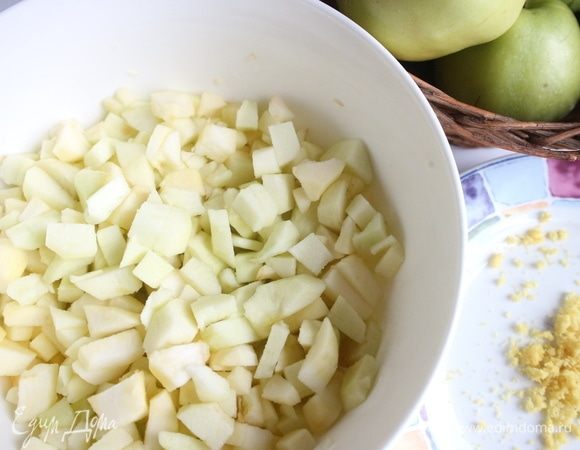 Из лимона выдавить сок. Поместить сок в большую миску, в которую вы будете складывать яблочные кубики. Яблоки (500 граммов) очистить от шкурки, нарезать на четвертинки, вынуть семенную часть. Нарезать мелкими кубиками. Поместить в миску с лимонным соком, перемешать. В сотейнике смешать сахар (75 г) с 50 мл воды. Поместить сотейник на средний огонь. Добавить яблоки, ванильный сахар. Проварить на медленном огне до мягкости яблок, поместить яблоки на сито, дать стечь жидкости.  
С лимона снять цедру.