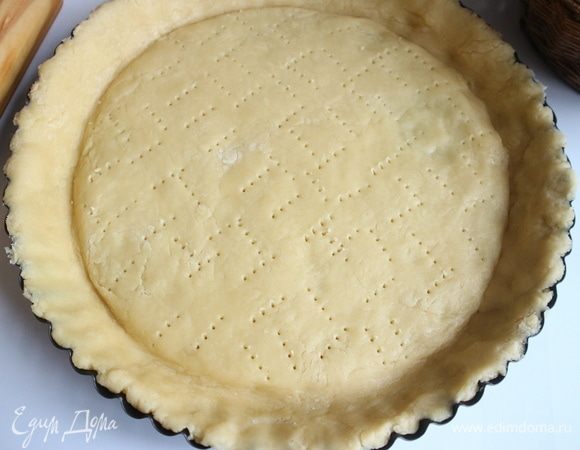 Достать тесто из холодильника, раскатать (маленький кусочек теста можно оставить для украшения), поместить в форму, наколоть вилкой тесто. Убрать в холодильник на 30 минут.