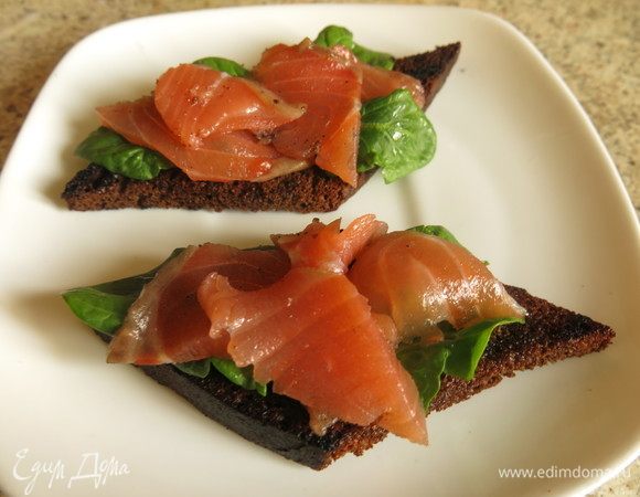 На зелень выкладываем пластинки лосося. Солила сама, в соли с сахаром со специями.