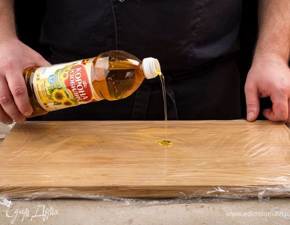 Для того чтобы свернуть рулет, натяните пищевую пленку на разделочную доску.