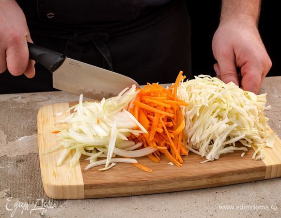 Нашинкуйте капусту, морковь и лук.